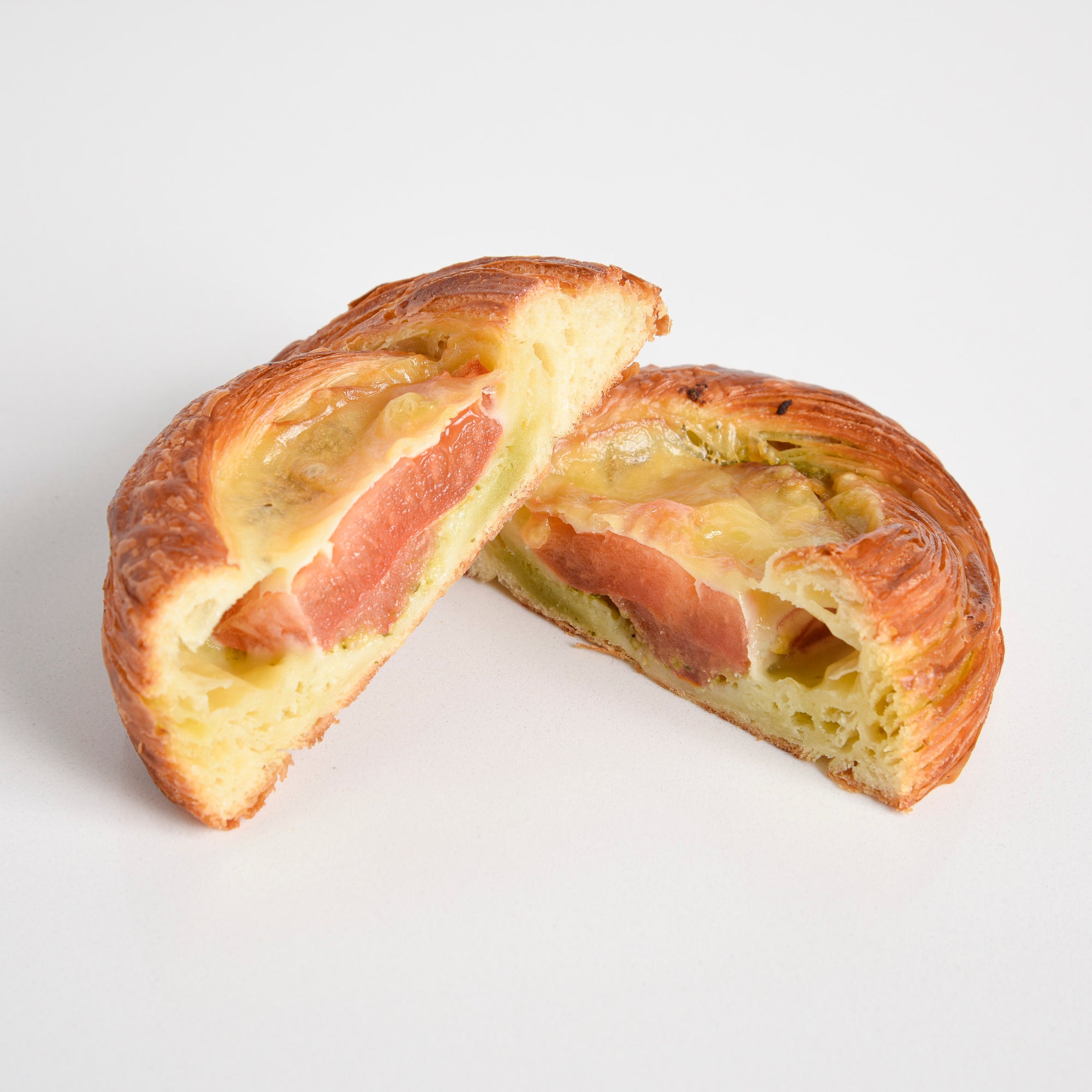 Cross section of Le fournil bakery danoise salée danish filled with tomato, pesto, and smoked cheddar cheese