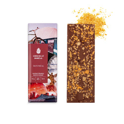 Open milk chocolate bar with maple flakes featuring Montreal landscape by Chocolat boréal.