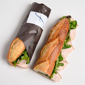 Packaged Le fournil bakery sandwich dinde canneberges smoked turkey with cranberry mayonnaise and lettuce for lunch to go